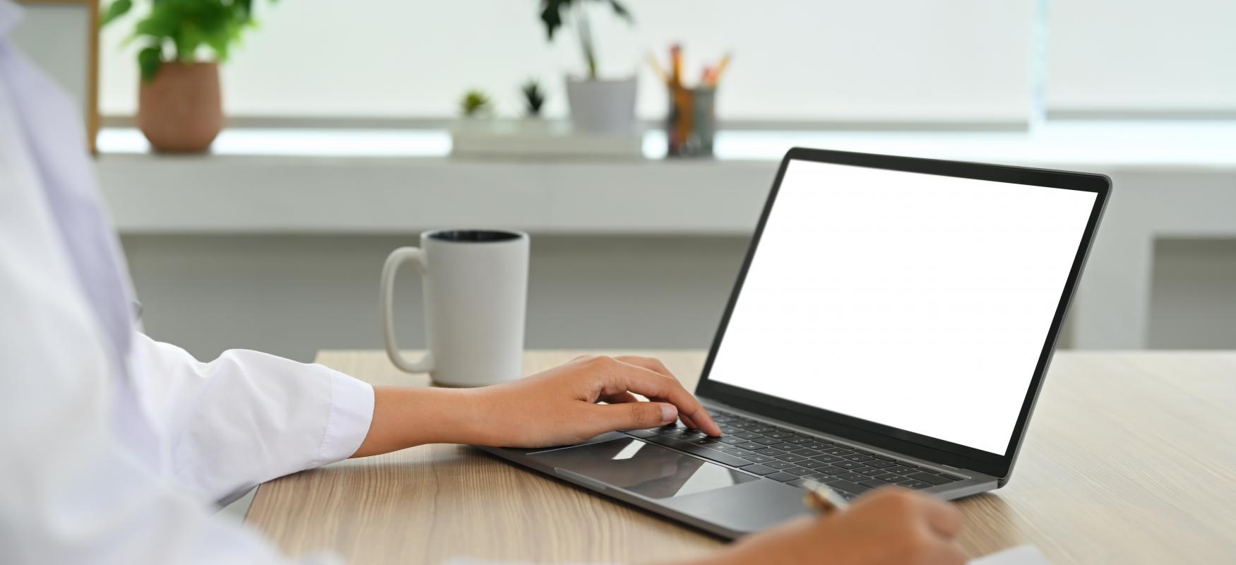 Læge sidder og kigger på computer