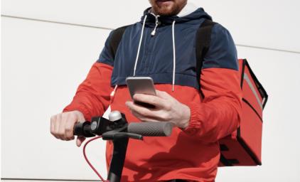 Young man on a electrical scooter using GPS on smartphone