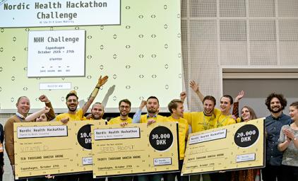 Group of people cheering and holding prize checks
