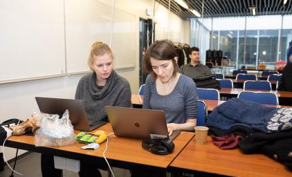 Two people in front of a laptop at a hackathon in Reykjavik.