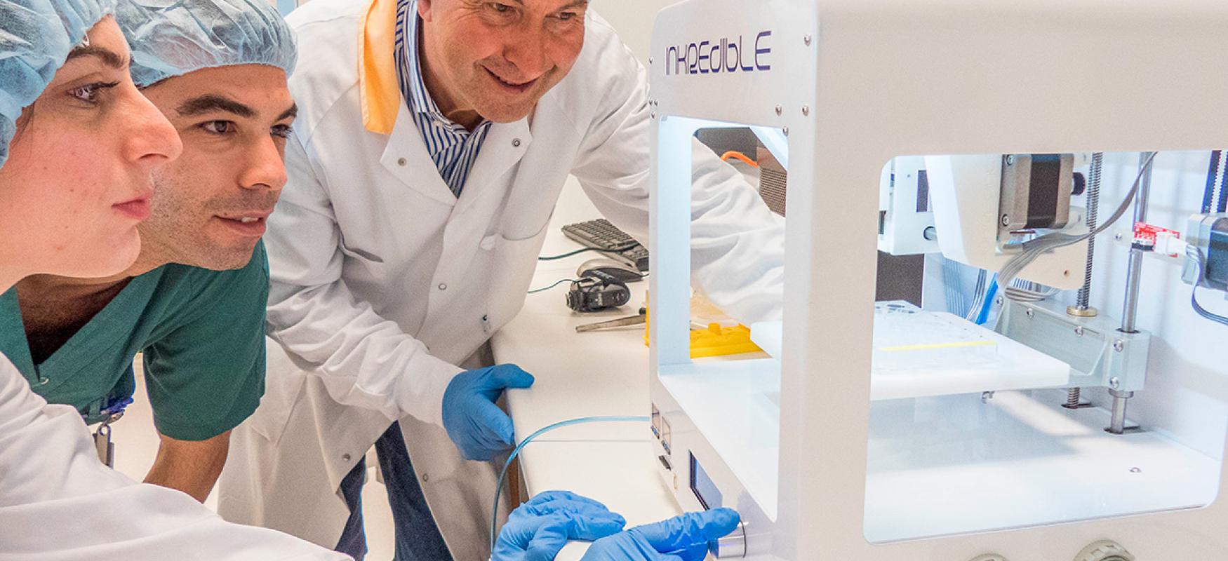 Paul-Gatenholm (right) with two assistanst using a 3D printer. 