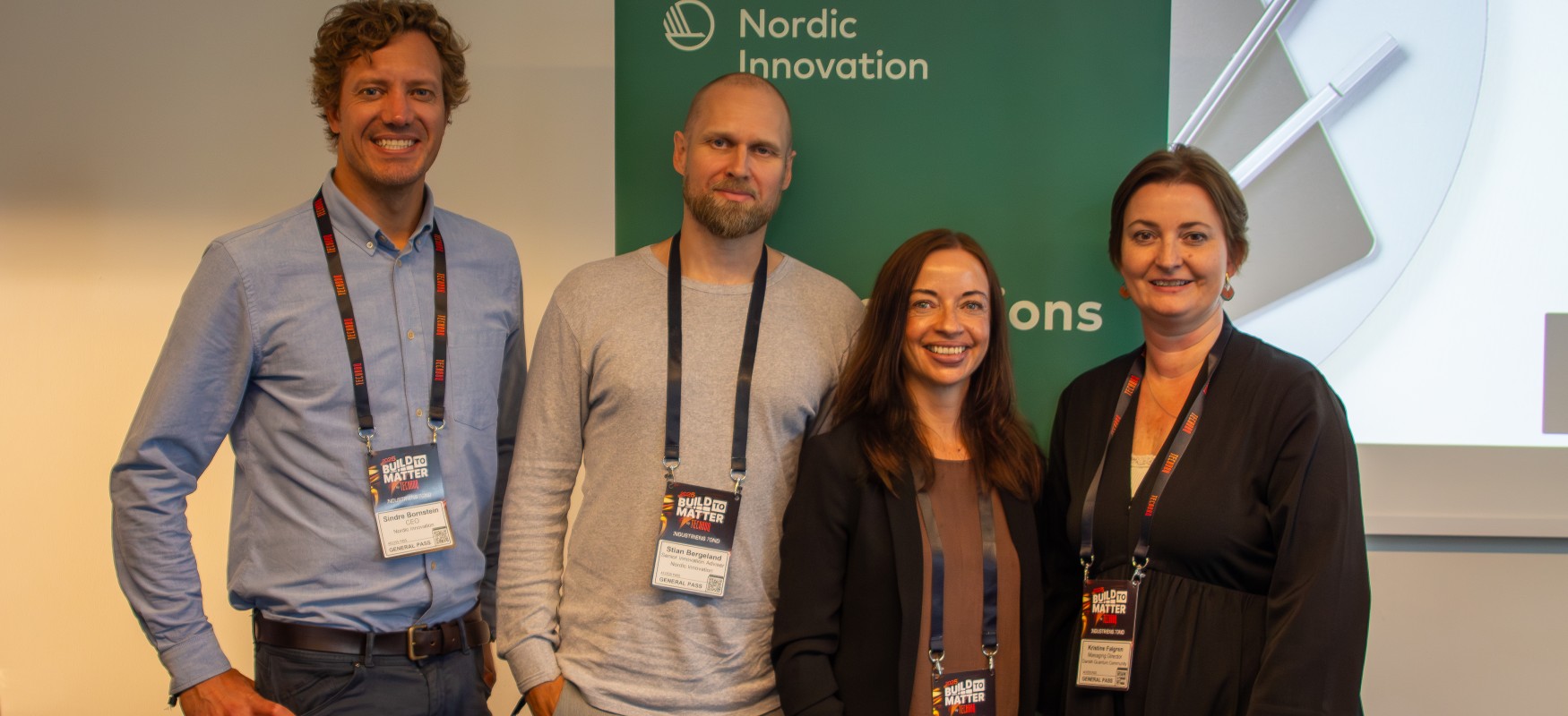 Four persons posing for a photo infront of a Nordic Innovation roll up