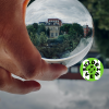 Person holding glass globe with reflecting building and trees in the background. WCEFonline sideevent logo